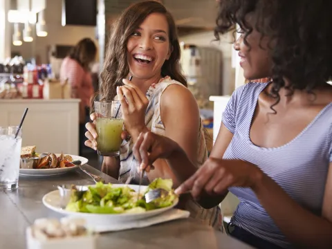 Two women eat a healthy lunch together.