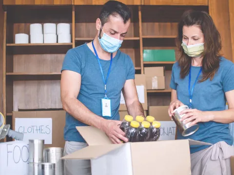 Two food drive volunteers wearing face masks.