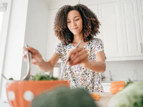 A woman making a salad at home.