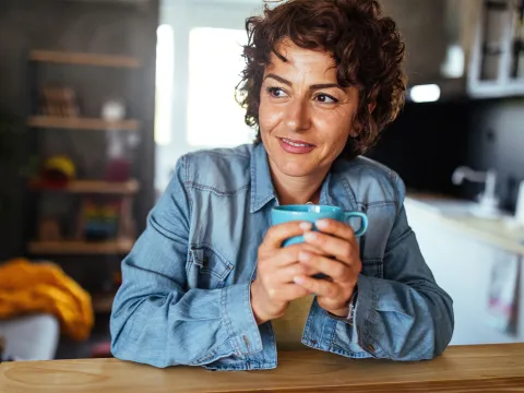 A woman drinking tea at home.