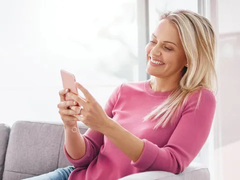 A woman on her phone, happily.