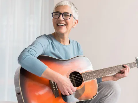 A woman strumming a guitar. 