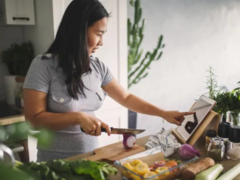 A young woman cooking at home.