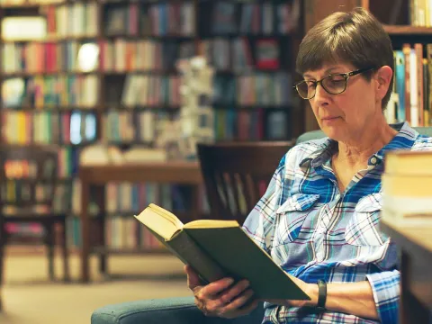 Woman reading book in library