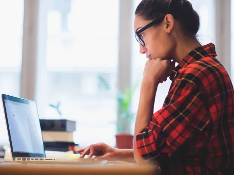 A woman focused on a task on her laptop