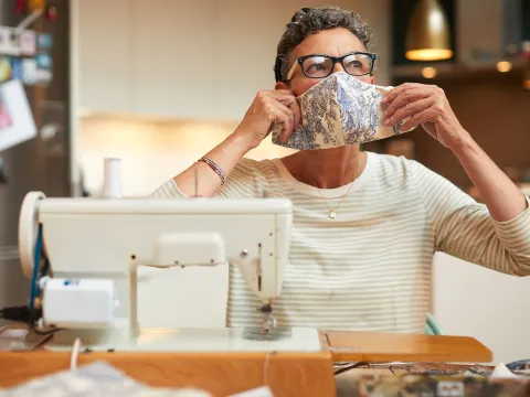A woman sewing a custom face mask. 