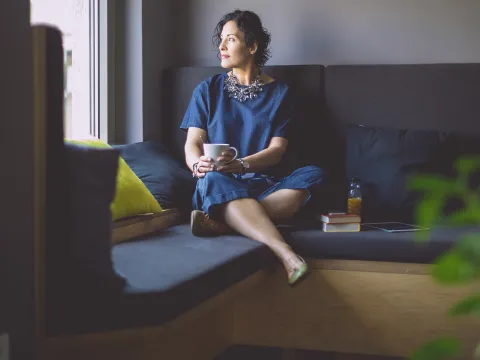 Woman on a couch with coffee.