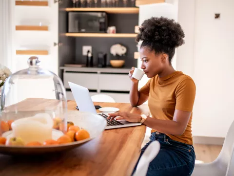 Women drinking coffee working on laptop