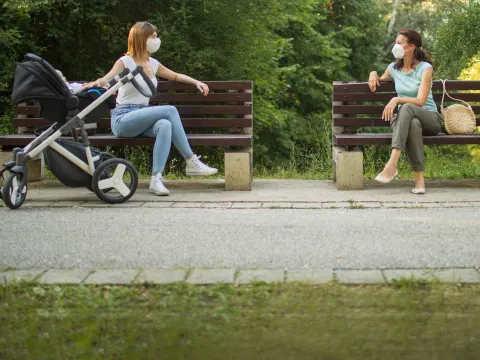 Two women social distancing outdoors.