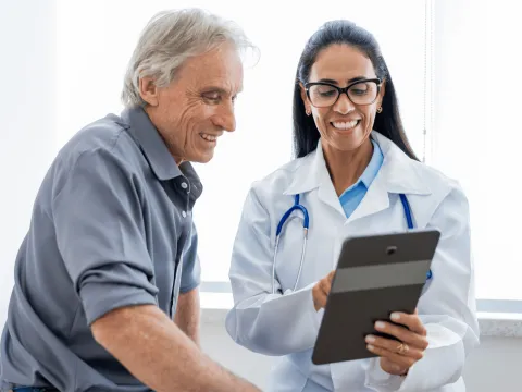 An older man speaking to a female physician.