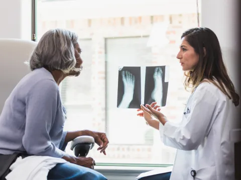 A patient and physician looking at foot x-rays