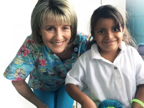 a woman poses with a child