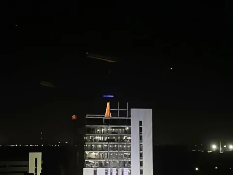 Innovation Tower is spotlighted on Thursday during the building's topping out ceremony.