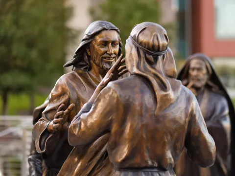 Statue of Jesus approaching a man to heal him.