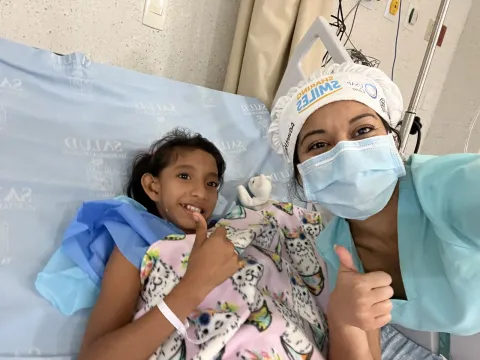 a nurse and a girl giving a thumbs up