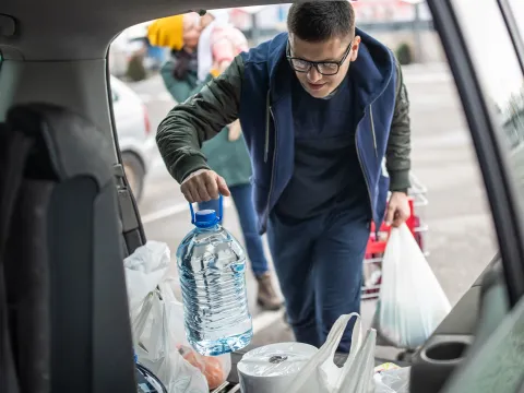 Man loading supplies into a car.