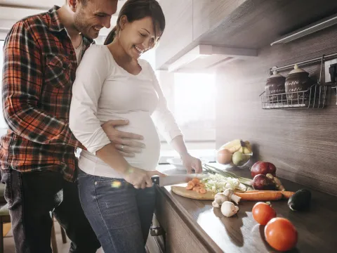 A pregnant woman prepares a healthy meal.