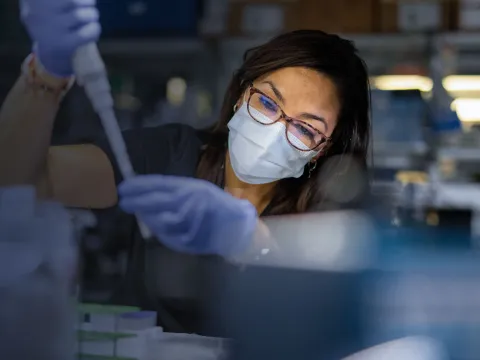 Masked Woman in Lab holding a syringe