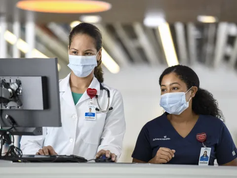 Two female physicians looking at a computer