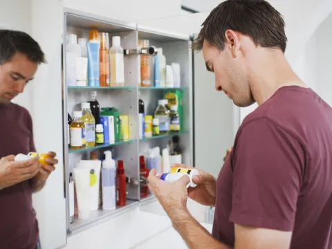 Man cleaning medicine cabinet