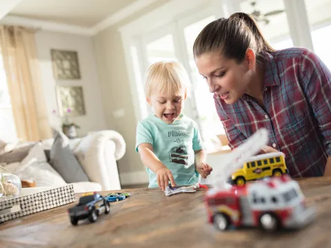 Mom playing cars with her son.