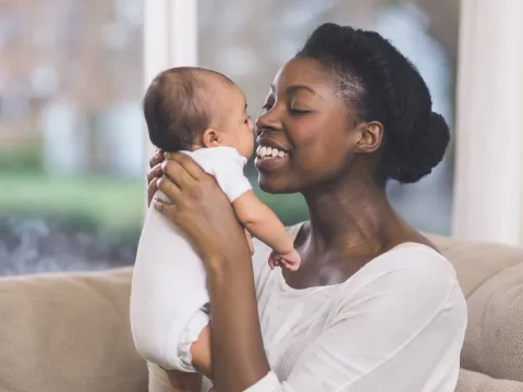 Mother holding her baby and smiling.