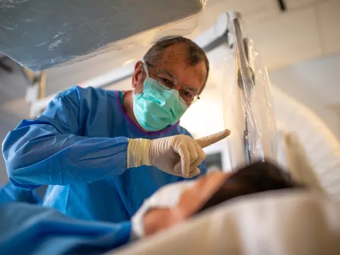 Neuro surgeon holding up a finger for a patient.