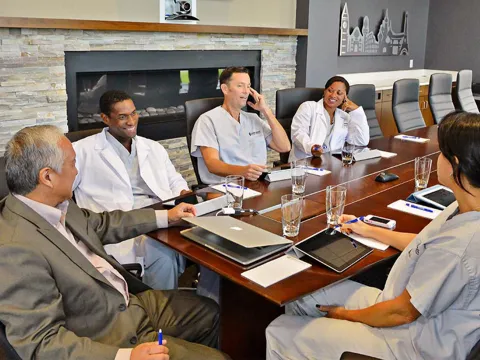 People having a meeting in the Nicholson Center Executive Boardroom.