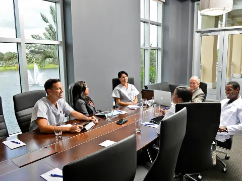 People having a meeting in the Nicholson Center Executive Boardroom.