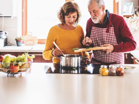 A mature couple cooking dinner.