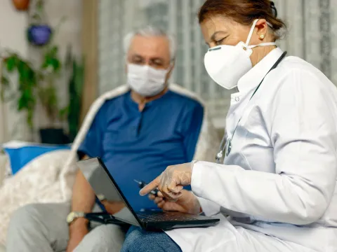 An older man being seen by a doctor. 