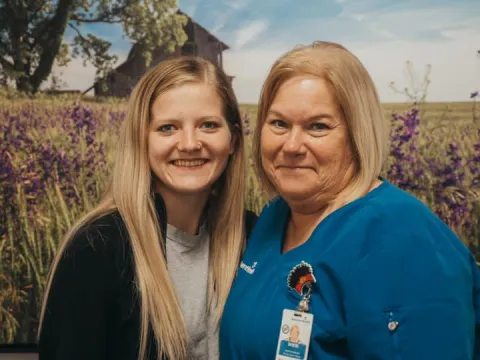 ottawa two nurses standing in front of flower picture