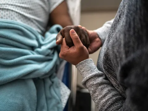 Man holding a patient's hand.