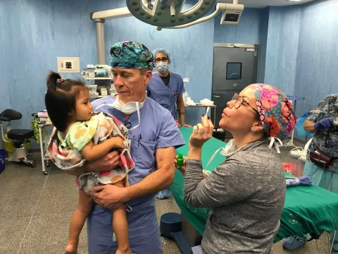 a child being held by a doctor