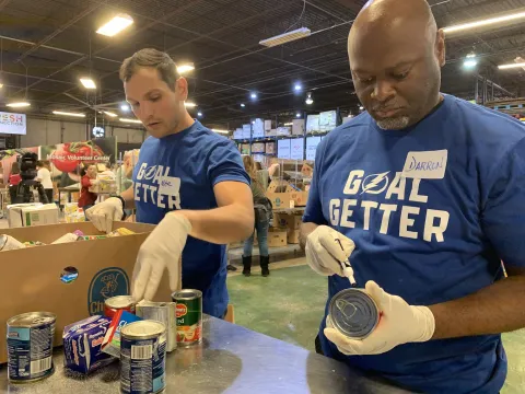 Two male volunteers labeling food donations