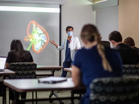 An AdventHealth physician conducting a lecture to her colleagues.