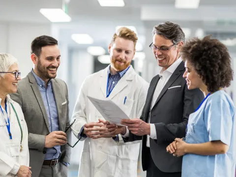 Physicians smiling and talking in hospital hallway