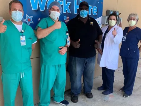 Physicians wearing masks give thumbs up