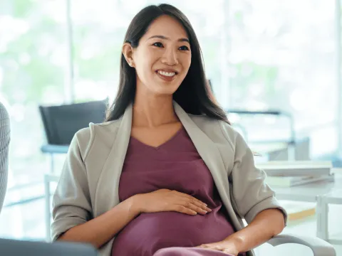 Pregnant woman smiling while at an appointment.