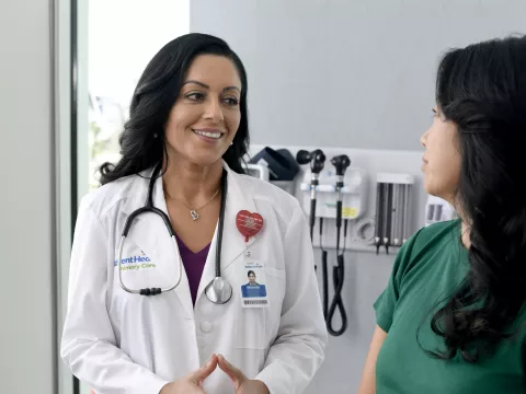 A Primary Care+ Physician Speaks to a Patient in an Exam Room