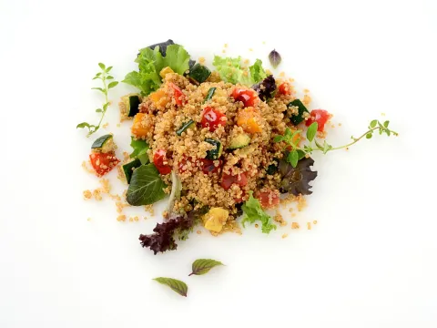 a large scoop of cooked quinoa, mixed with colorful squash and peppers