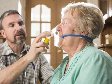 A doctor giving an athsma patient some oxygen through mask