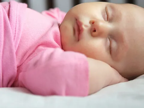 Adorable infant sleeping in her crib.