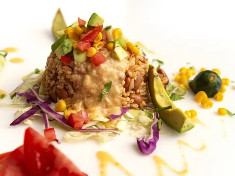 Scoop of taco lunch bowl ingredients with avocado and pepper garnishes