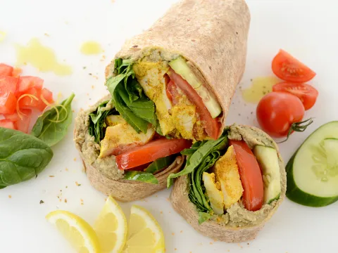 Sliced chicken wrap with vegetable and lemon garnishes
