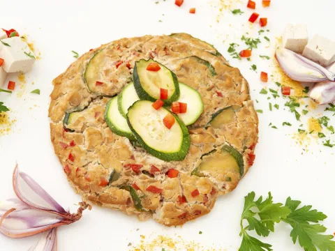 a flat, plant-based frittata, with zucchini and red bell peppers