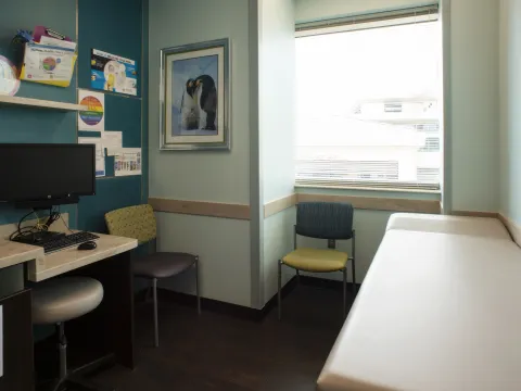 Room furnished with bed, chairs, and desks