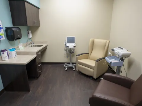 Room with medical equipment, chairs, and a desk