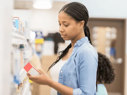 Woman looking at a product at a pharmacy.