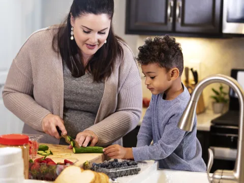 Woman Chopping Veggies with her son